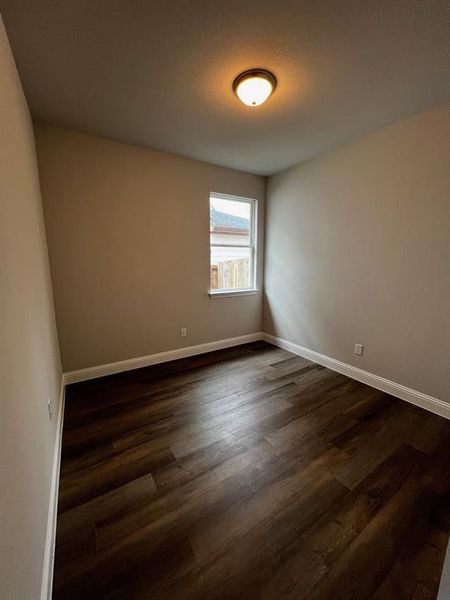 Spare room featuring dark wood-type flooring