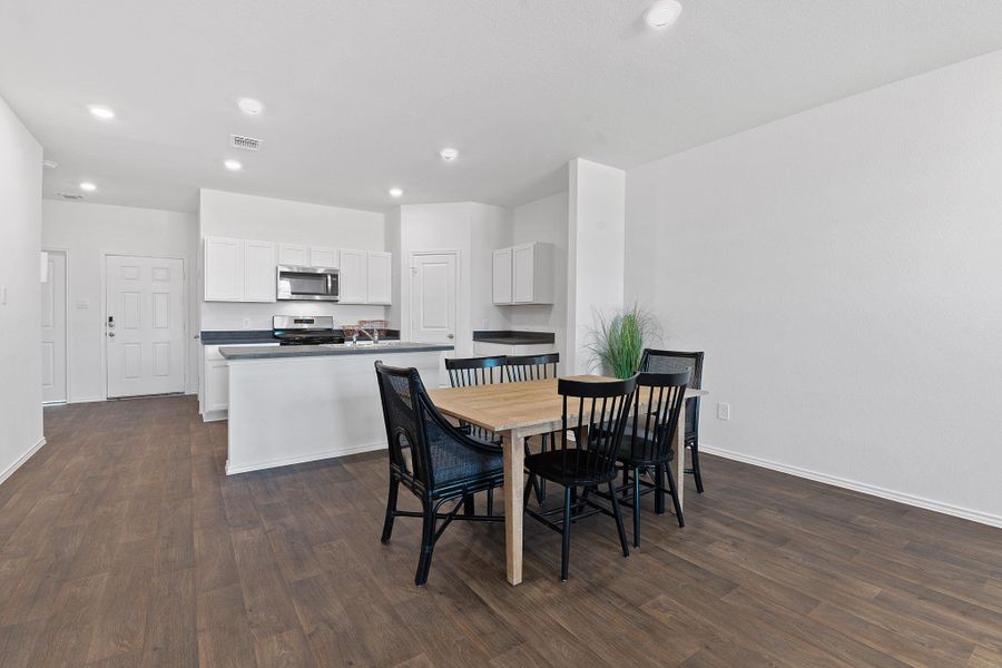 Dining area featuring baseboards, visible vents, dark wood-type flooring, and recessed lighting