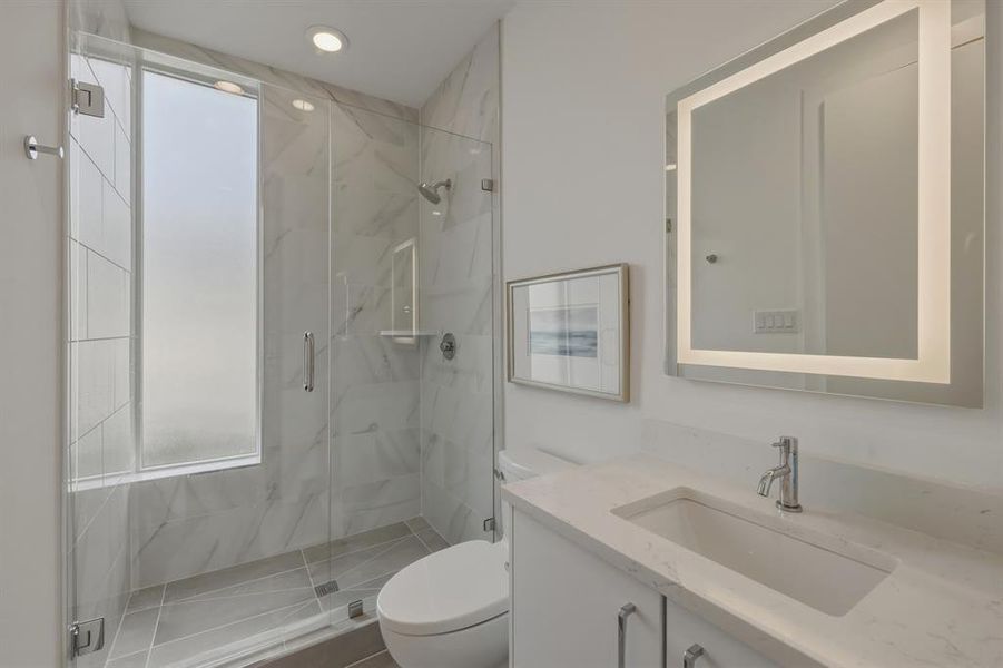Full bathroom featuring vanity and a marble finish shower