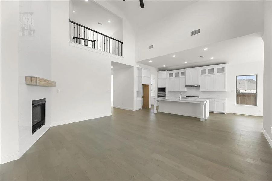 Unfurnished living room with sink, dark hardwood / wood-style floors, and a high ceiling