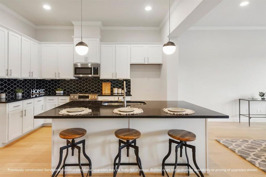 Featuring ample cabinetry, open shelving, and a seamless connection to the living and breakfast rooms, this island kitchen is both open and functional.