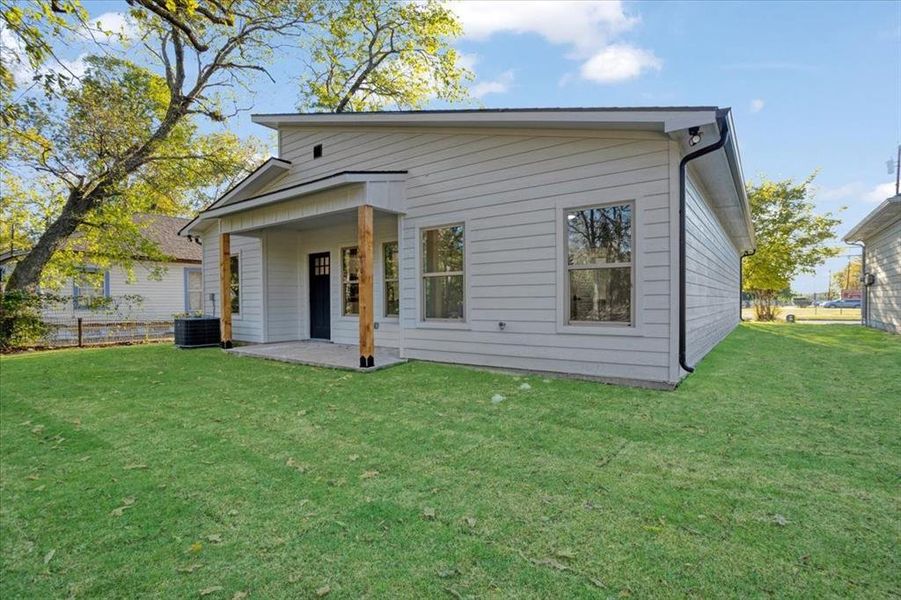 Rear view of house featuring a patio area, a lawn, and central AC unit