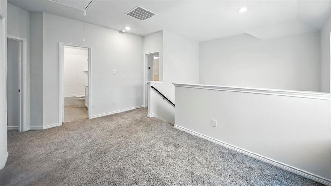 Unfurnished room with attic access, light carpet, and recessed lighting