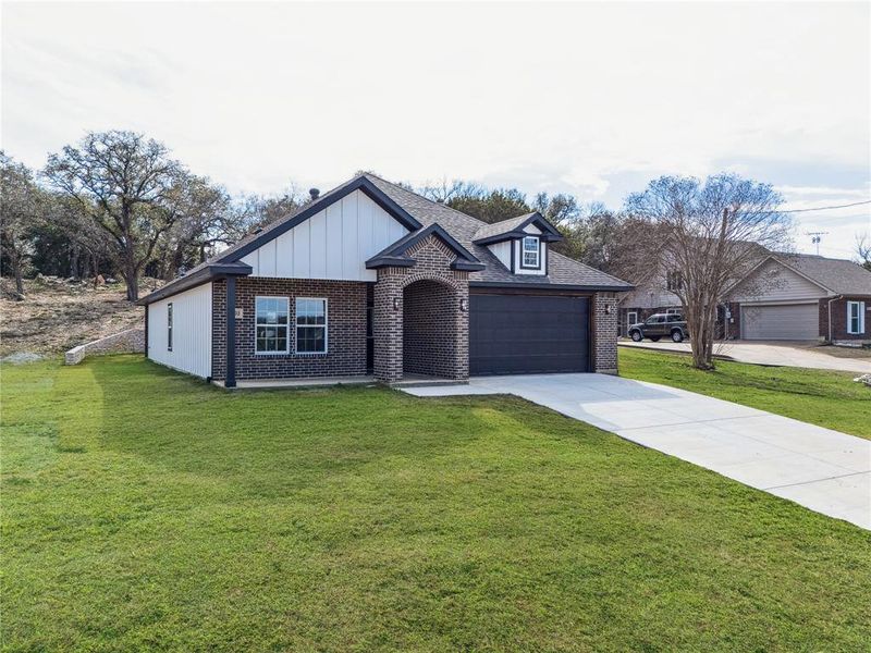 Contemporary brick and vertical siding exterior with a dark gray garage door
