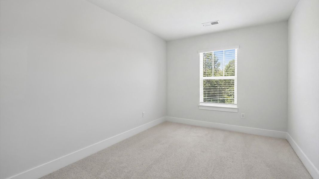 Notable bedroom offering soft carpet, a walk-in closet, and expansive windows overlooking the yard near Downtown Greenville Notable bedroom offering soft carpet, a walk-in closet, and expansive windows overlooking the yard near Downtown Greenville