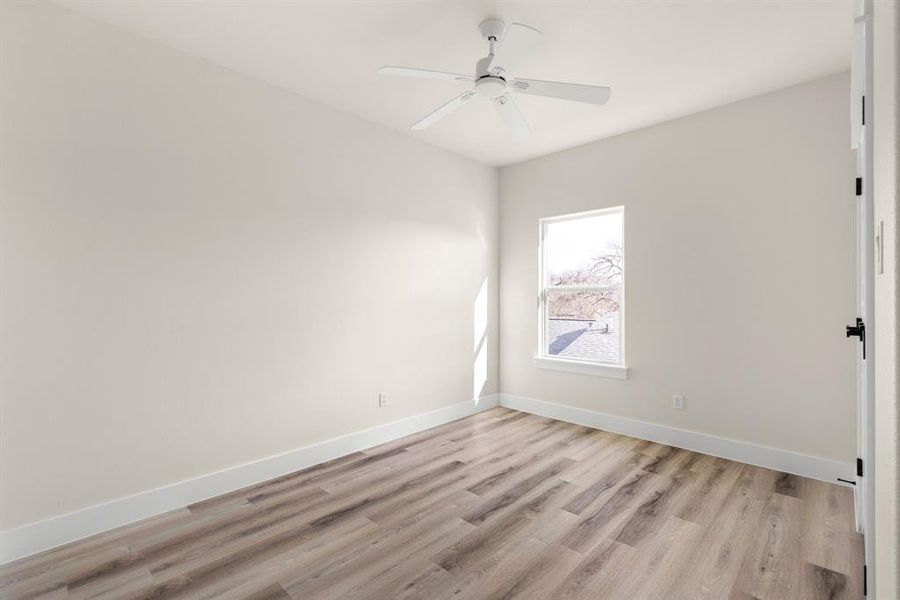 Empty room featuring ceiling fan and light hardwood / wood-style flooring