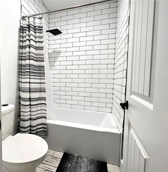 Second Bathroom with tile flooring, shower / tub combo, and toilet