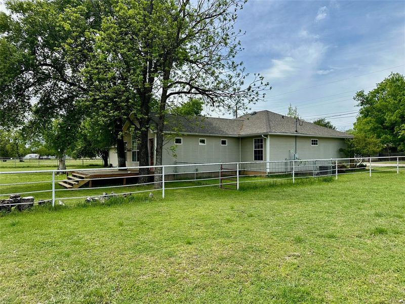 Rear view of house featuring a fenced backyard and a shingled roof