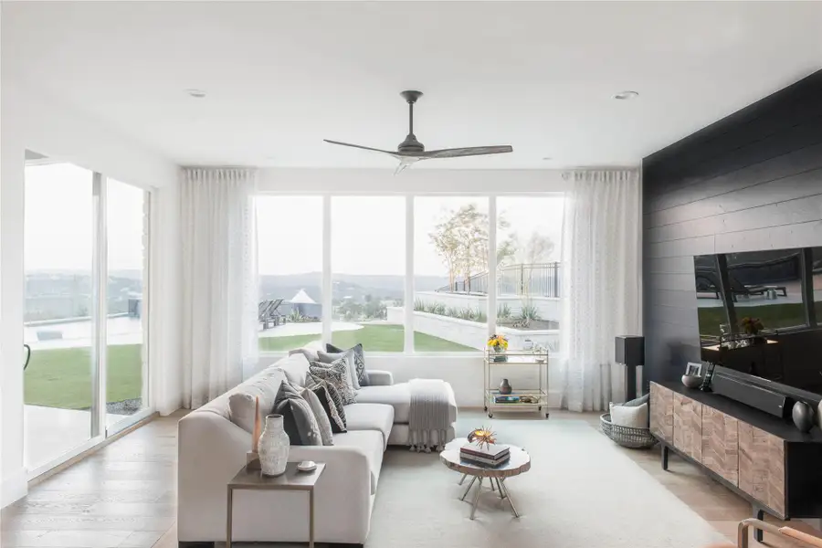 Living room featuring light wood-style floors, wooden walls, and ceiling fan