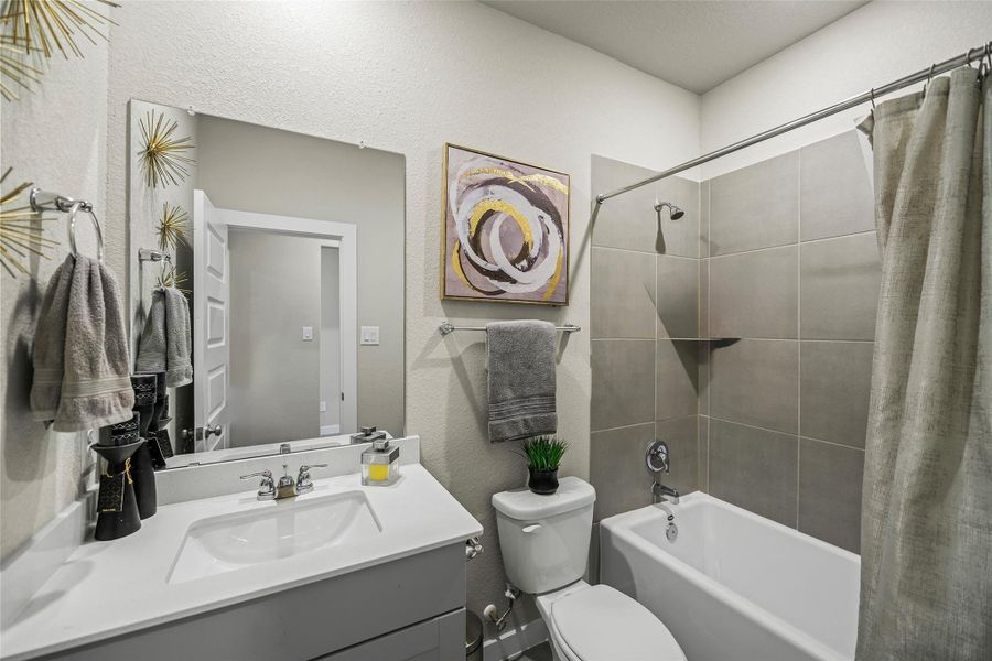 Modern bathroom with a sleek vanity, large mirror, and stylish tile shower.