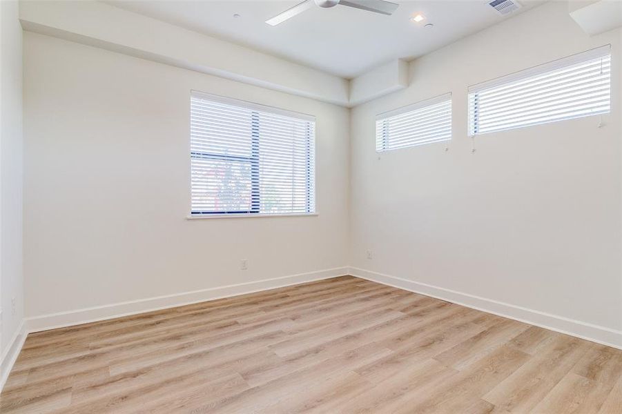 Unfurnished room with ceiling fan and light wood-type flooring