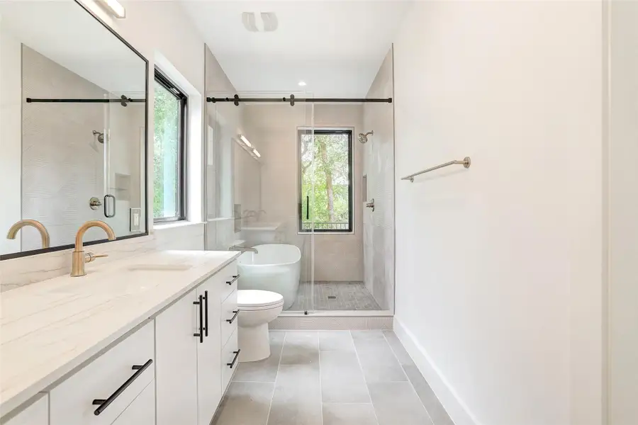 Bathroom with vanity, a shower stall, and tile patterned floors