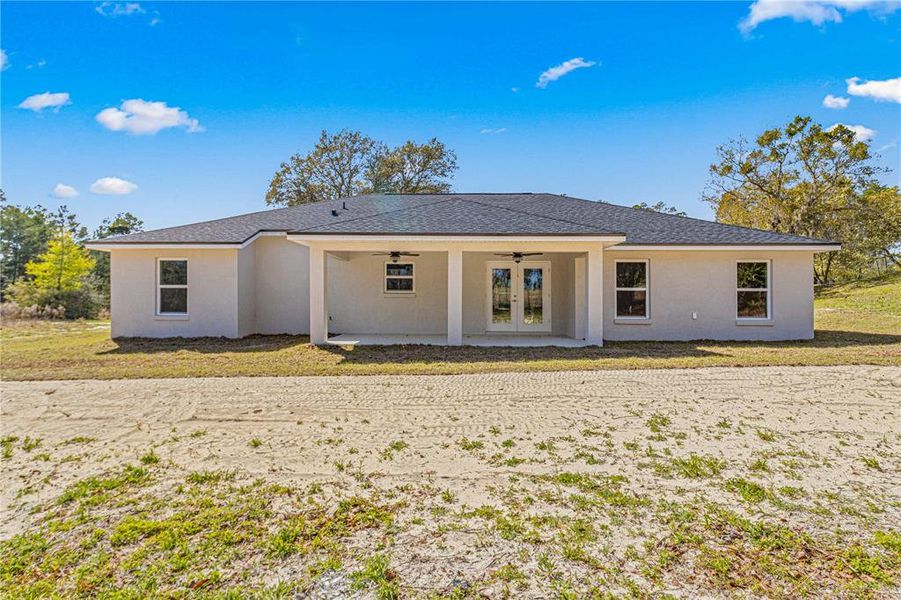 REAR ELEVATION OF HOME- LANAI HAS 2 CEILING FANS