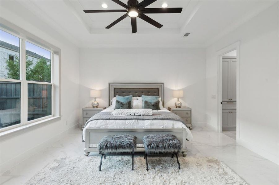 Bedroom featuring a raised ceiling, ornamental molding, and ceiling fan