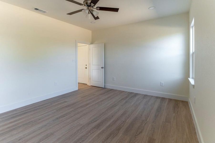 Unfurnished room with wood finished floors and a ceiling fan