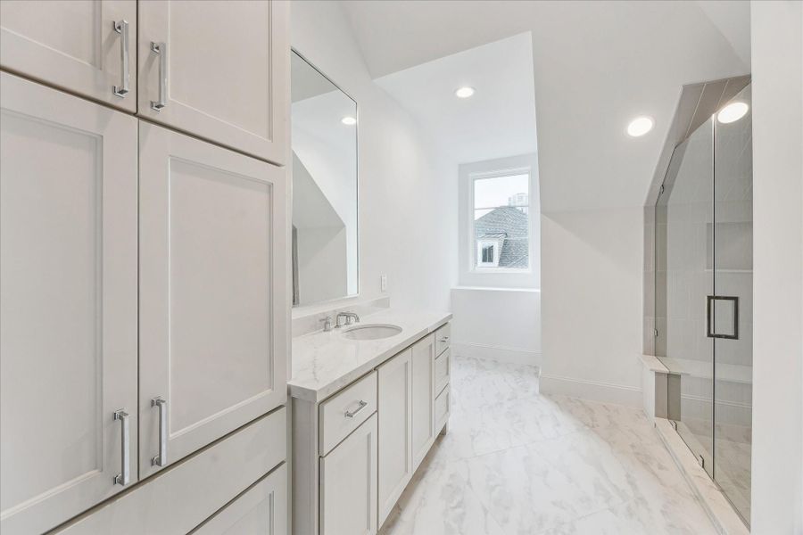 Full bathroom on third floor with large counter space, glass-encased shower, and storage.