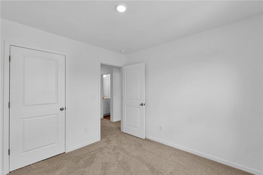 This spacious bedroom offers comfortable carpeting