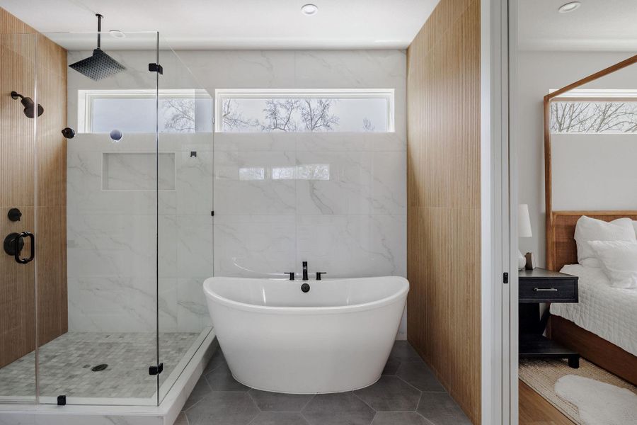 Full bath with connected bathroom, tile walls, a marble finish shower, a soaking tub, and tile patterned floors
