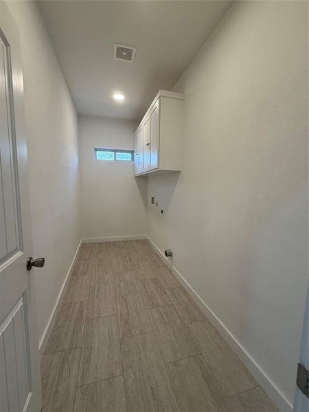 Laundry room featuring cabinet space, baseboards, hookup for a washing machine, and visible vents