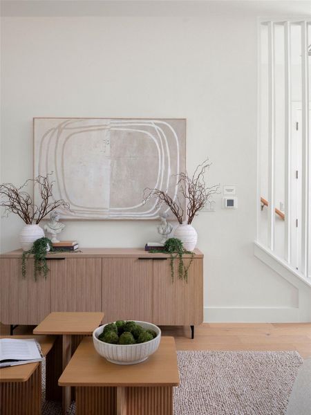 Hardwood floors and a textured area rug define this luminous interior space.