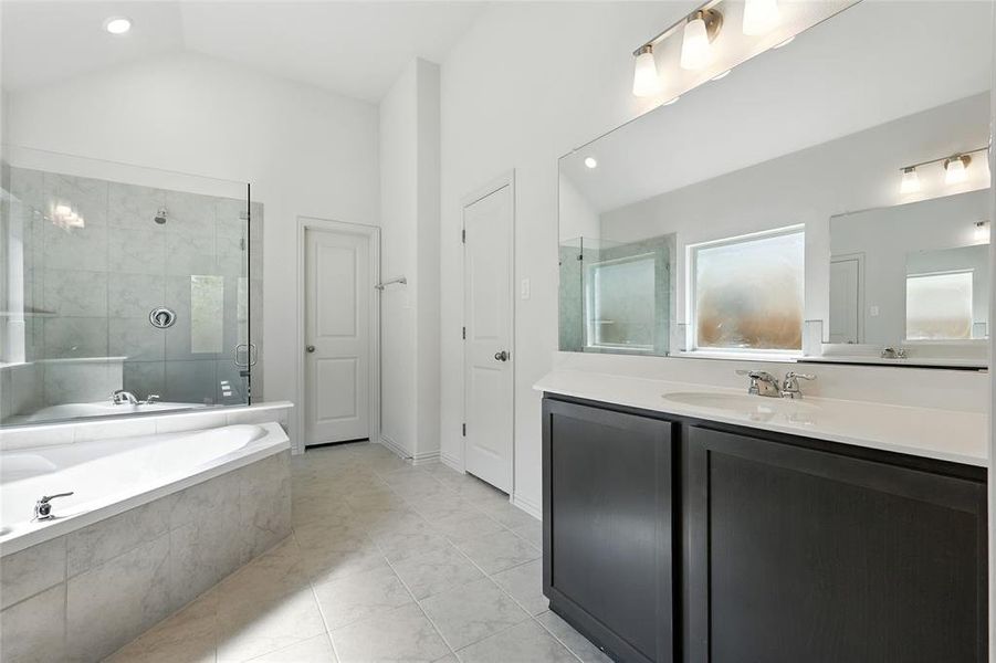 Full bathroom featuring vanity, a stall shower, a bath, vaulted ceiling, and recessed lighting Full bathroom featuring vanity, a stall shower, a bath, vaulted ceiling, and recessed lighting