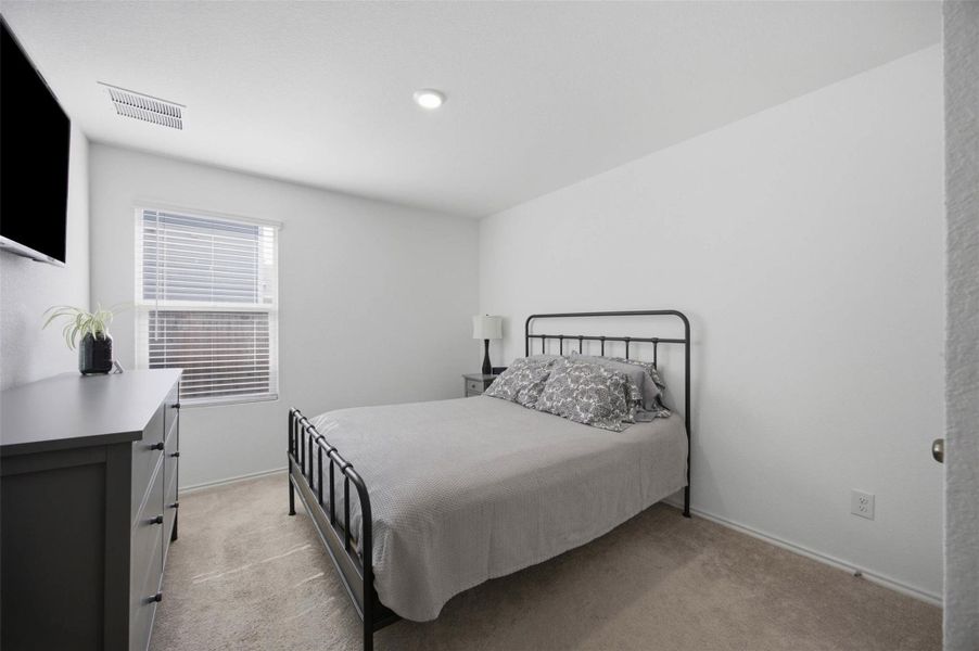Warm carpeting floor and smooth walls define this comfortable bedroom layout.