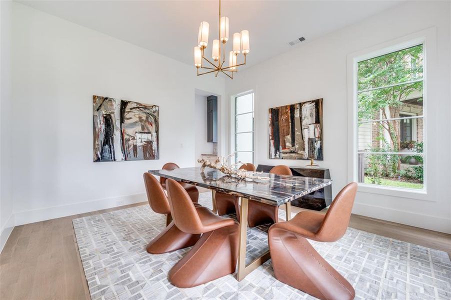 Dining area featuring light hardwood / wood-style floors and a notable chandelier