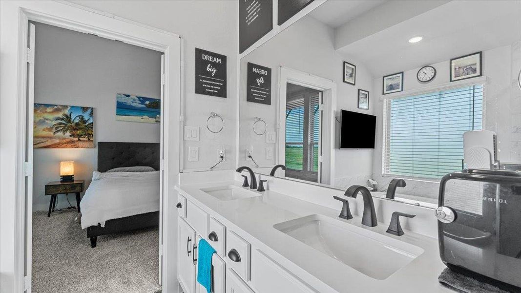 Ensuite bathroom with double vanity, light colored carpet, and recessed lighting Ensuite bathroom with double vanity, light colored carpet, and recessed lighting