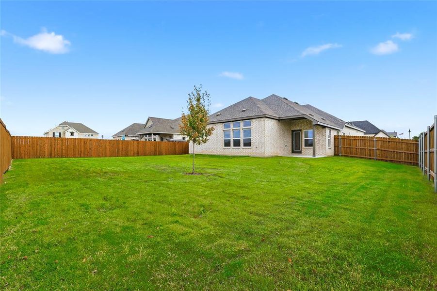 Back of property with brick siding, a fenced backyard, and a patio area Back of property with brick siding, a fenced backyard, and a patio area