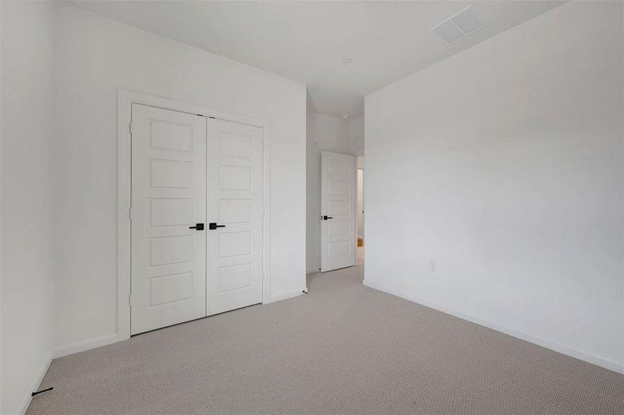 Neutral tone carpeting extends throughout this room, featuring white walls and white trim Neutral tone carpeting extends throughout this room, featuring white walls and white trim