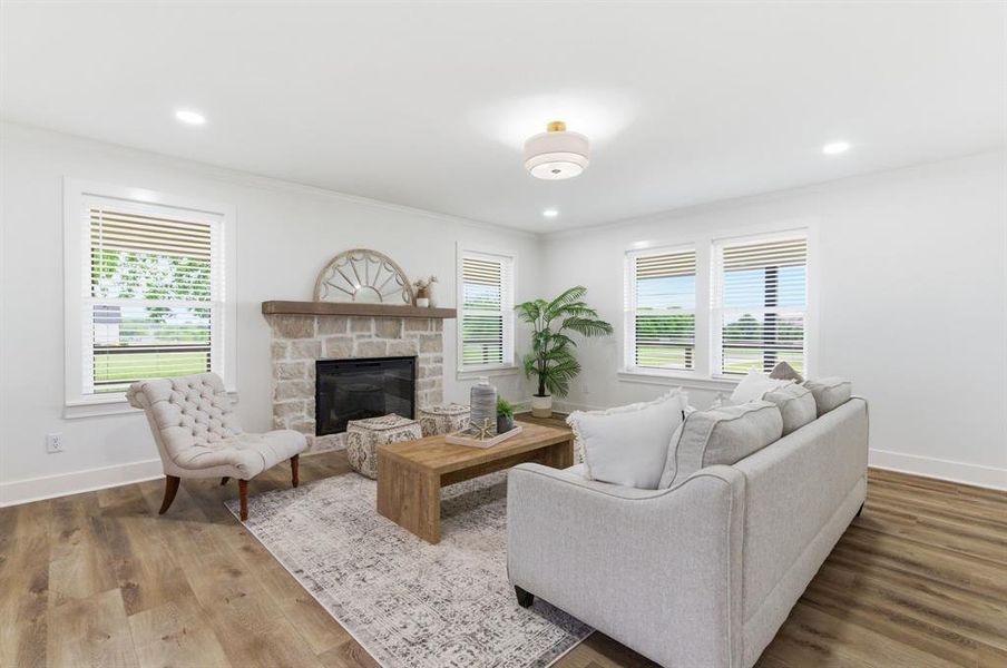 The living area features durable flooring, a stone fireplace with a wood mantle, and white walls with recessed lighting The living area features durable flooring, a stone fireplace with a wood mantle, and white walls with recessed lighting