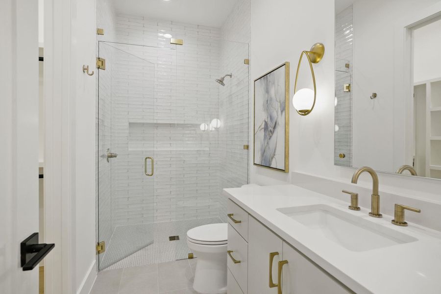 Full bathroom with tile patterned floors, vanity, a shower stall, and toilet