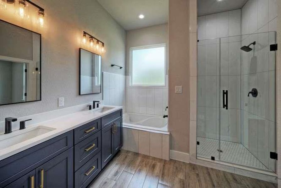 Dual vanities and a deep soaking tub complete this well-appointed bathroom.
