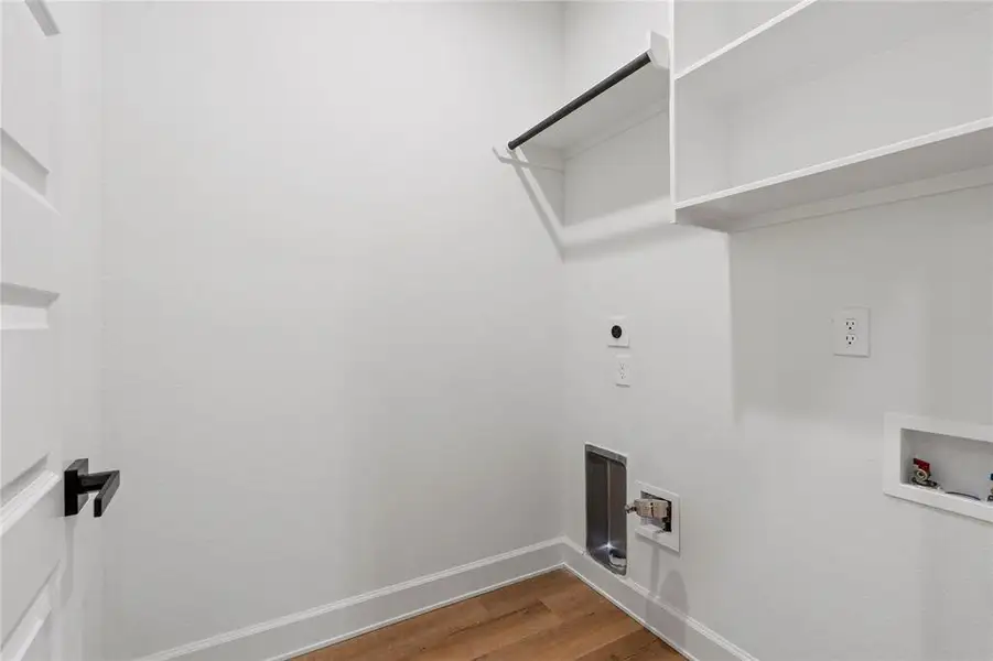 Spacious laundry room with convenient hookups, shelving, and a sleek modern design. Spacious laundry room with convenient hookups, shelving, and a sleek modern design.