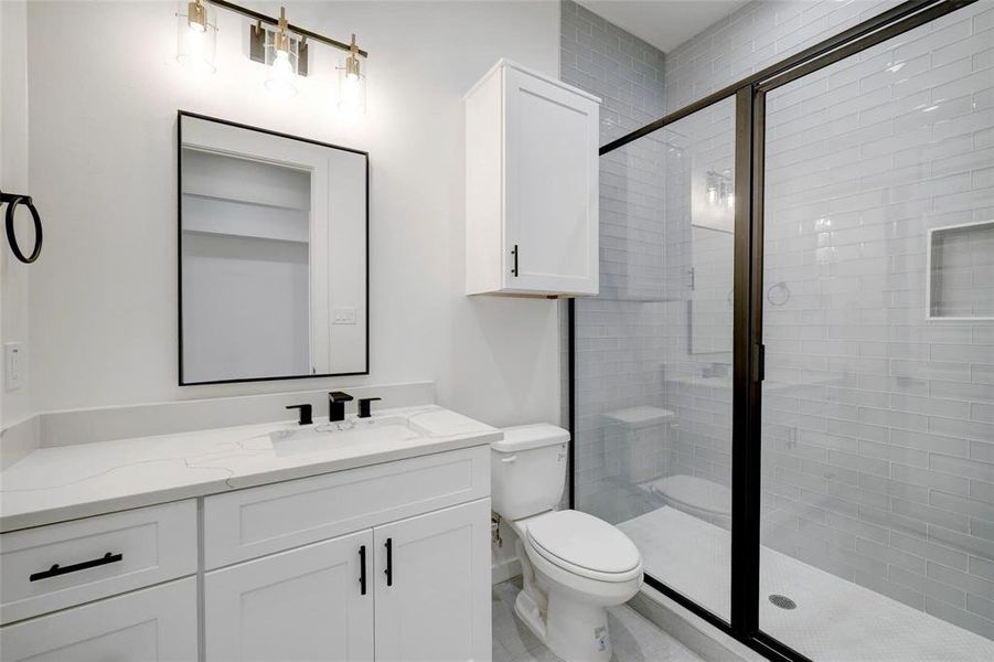 A modern bathroom featuring a shower stall and a sleek sink, designed for functionality and comfort. ster Bathroom