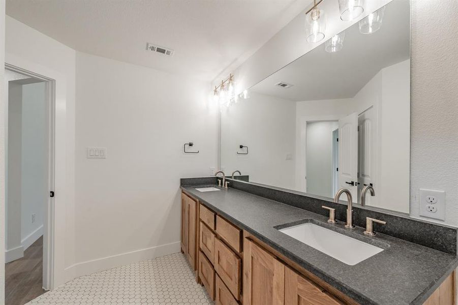 Full bath with double vanity and baseboards