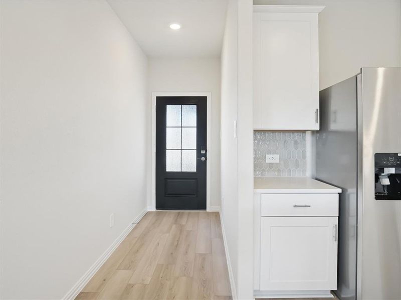 Doorway to outside featuring baseboards and wood finished floors