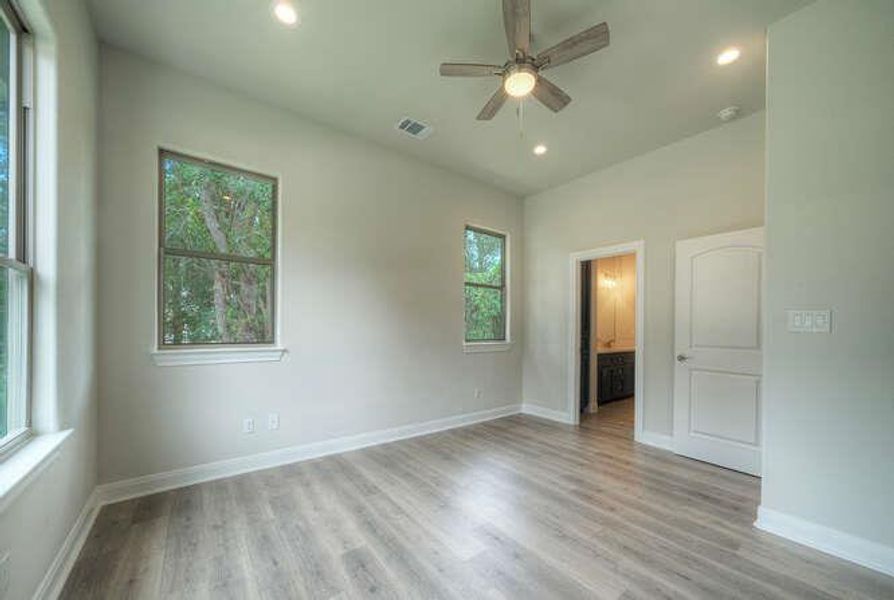 Empty room featuring plenty of natural light, ceiling fan, light wood finished floors, and recessed lighting
