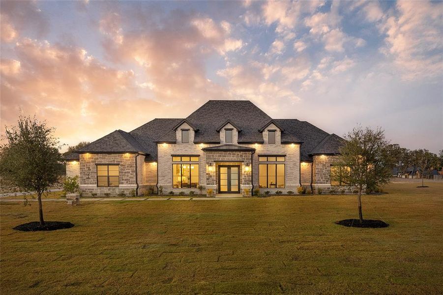French country style house with stone siding, a lawn, brick siding, french doors, and a shingled roof French country style house with stone siding, a lawn, brick siding, french doors, and a shingled roof