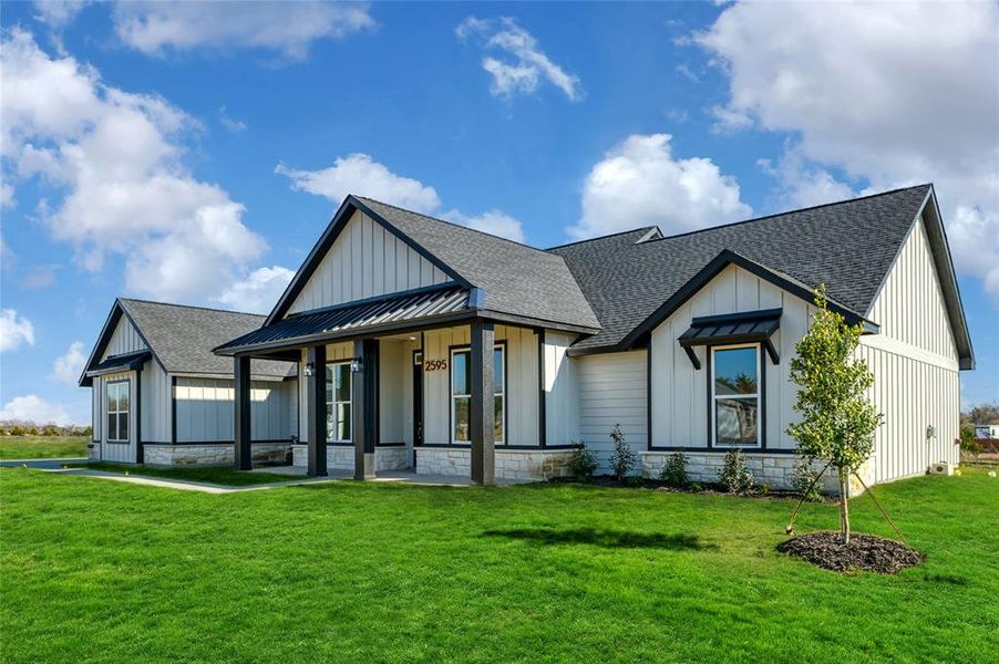 View of front facade with a front yard and covered porch