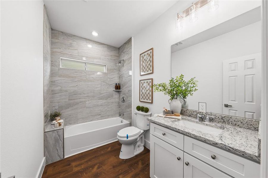 Bathroom featuring a white vanity with a granite countertop, undermount sink, and chrome faucet