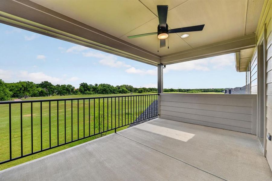 Covered balcony featuring concrete flooring and a black metal railing