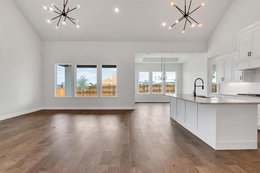 Kitchen with pendant lighting, dark hardwood / wood-style flooring, and white cabinets