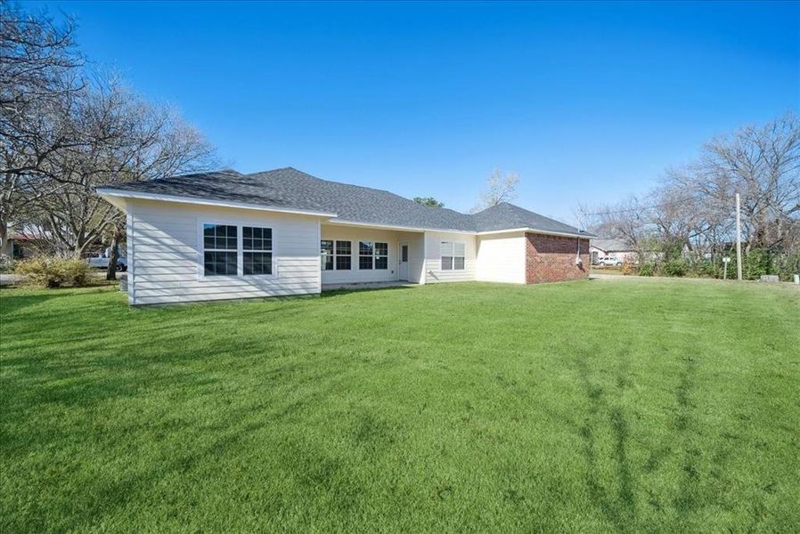 Back of house with a lawn