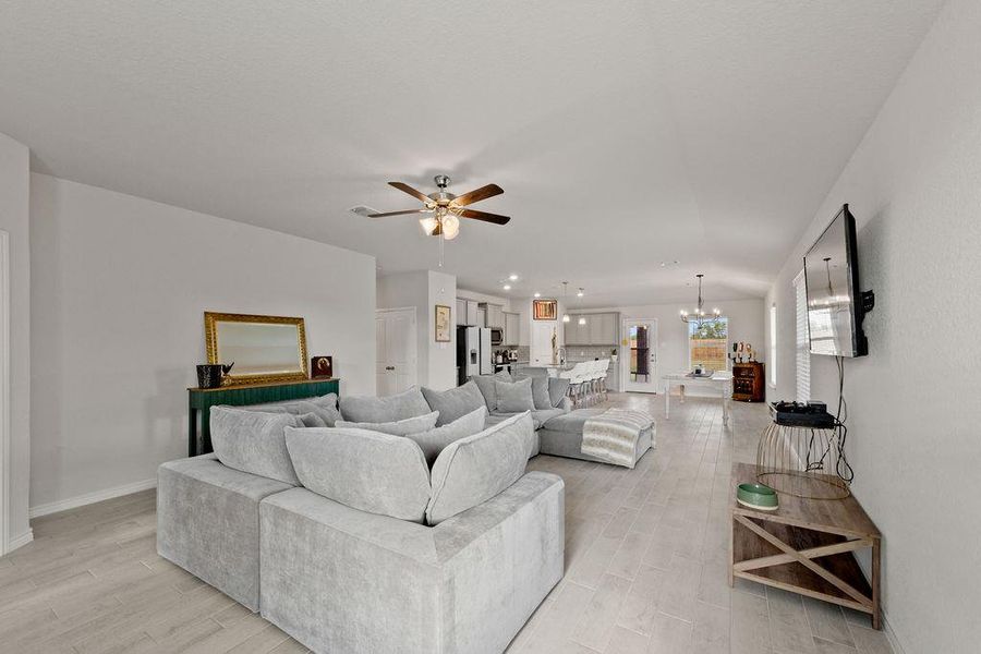 Living room with a chandelier, light wood-style floors, and a ceiling fan