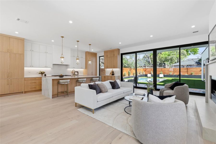 Living room with light wood-style flooring and recessed lighting