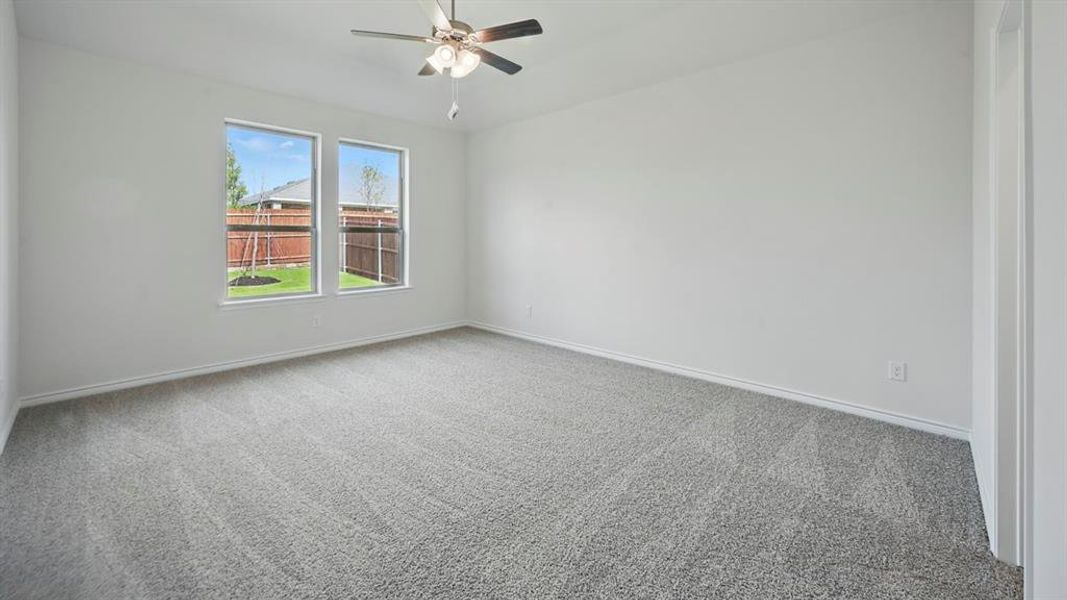 Spare room with carpet floors and a ceiling fan