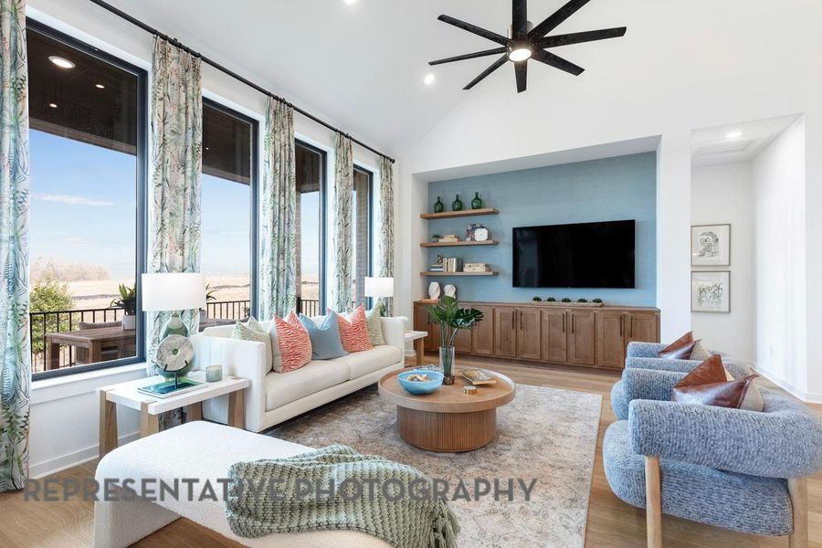 Living area with healthy amount of natural light, a ceiling fan, wood finished floors, recessed lighting, and lofted ceiling