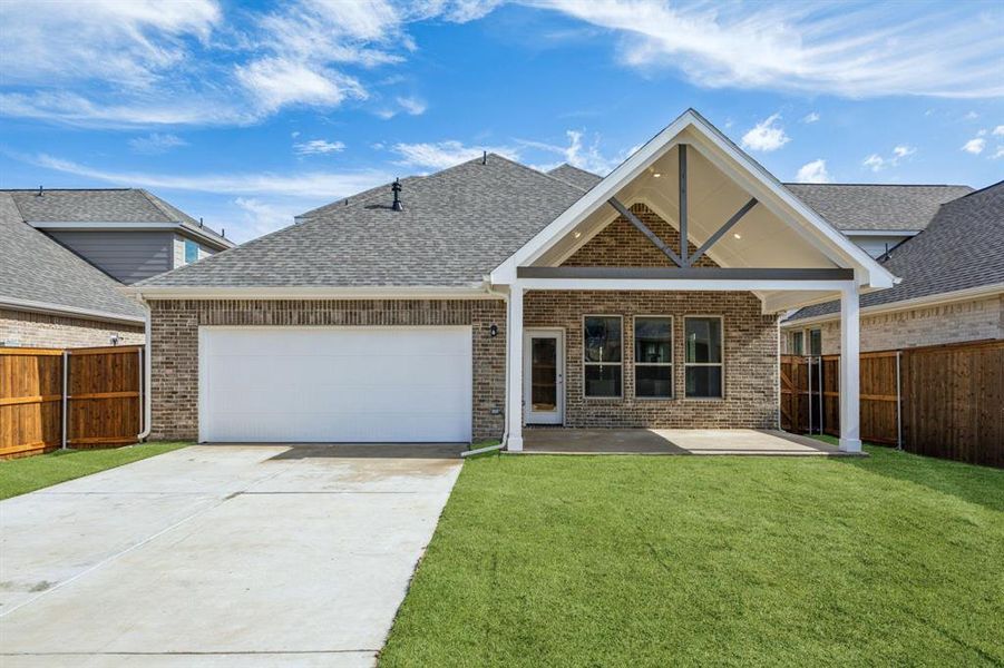 View of front facade with a garage, a patio area, and a front yard