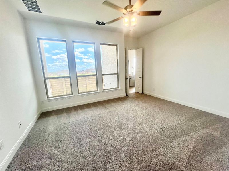Carpeted empty room featuring baseboards and a ceiling fan Carpeted empty room featuring baseboards and a ceiling fan